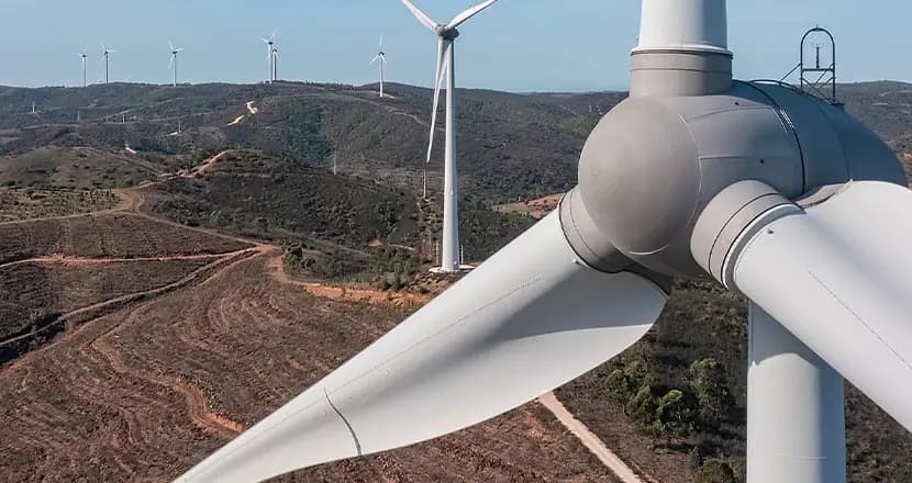 Close-up of wind turbine blades with multiple turbines in the background for renewable energy applications