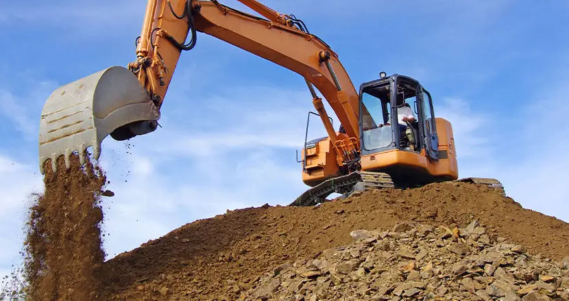 Excavator moving soil on construction site for heavy-duty sensor applications